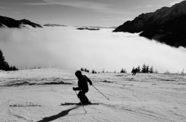 full length man skiing snowcapped mountains against sky