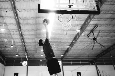 caucasian teenage boy playing basketball alone court