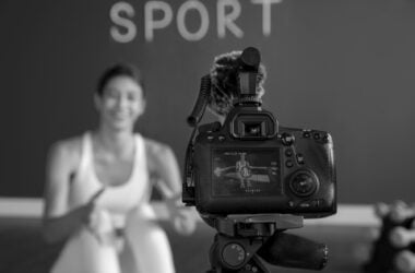 female fitness instructor teaching class home while using camera tripod
