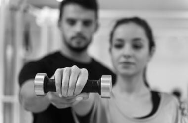 close up blurry woman exercising with dumbbell
